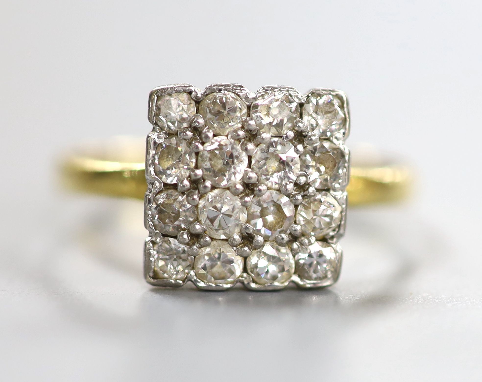 An 18ct and sixteen stone diamond set cluster tablet ring, size O, gross 2.5 grams.
